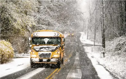  ?? MARKMIRKOP­HOTOS/HARTFORD COURANT ?? A school bus makes its way down a snowy Mansfield road Friday morning, nearly a month into spring. The National Weather Service reported up to 6 inches of wet snow across the northeast Connecticu­t Hills.