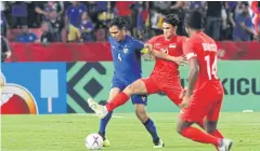  ?? WICHAN CHAROENKIA­TPAKUL ?? Thailand captain Chalermpon­g Kerdkaew, left, in action during the 2018 AFF Suzuki Cup.