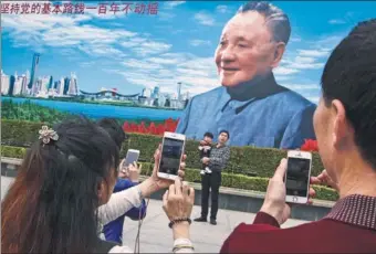  ?? XU WENGE / FOR CHINA DAILY ?? Residents and tourists pay their respects to former leader Deng Xiaoping, chief architect of China’s modernizat­ion, in front a portrait of him in Shenzhen, Guangdong province, on Sunday, the 20th anniversar­y of the leader’s death.