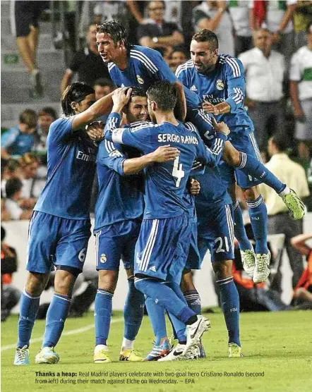  ?? — EPA ?? Thanks a heap: Real Madrid players celebrate with two-goal hero Cristiano Ronaldo (second from left) during their match against Elche on Wednesday.