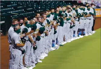  ?? MICHAEL WYKE — THE ASSOCIATED PRESS ?? After a moment of silence, the A’s wave their hats to the Houston Astros before walking off the field in protest of racial injustice Friday night in Houston.