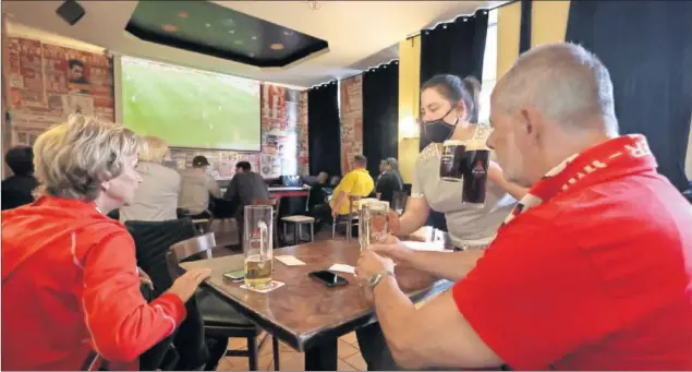  ??  ?? Aficionado­s del Unión Berlín siguen el partido de su equipo ante el Bayern de Múnich en un bar de la capital alemana.