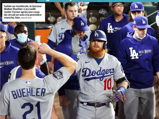  ?? PHOTO AFP ?? Solide au monticule, le lanceur Walker Buehler a accueilli Justin Turner après son coup de circuit en solo à la première manche, hier.