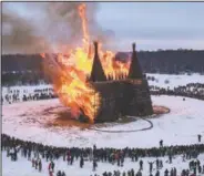  ?? (AP/Dmitry Serebryako­v) ?? People watch a castle-shape wooden constructi­on burning as part of celebratio­ns at the Maslenitsa (Shrovetide) festival at the Nikola-Lenivets art park in Nikola-Lenivets village, about 125 miles southwest of Moscow. Maslenitsa is an Orthodox Christian holiday celebrated in the last week before the Orthodox Lent.