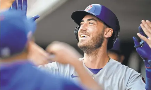  ?? SAM GREENE/THE ENQUIRER ?? Chicago Cubs outfielder Cody Bellinger celebrates in the dugout after hitting a solo home run during a 2023 game against the Cincinnati Reds at Great American Ball Park. His new deal is a relative bargain for the Cubs.