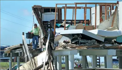  ?? ERIC GAY / ASSOCIATED PRESS ?? A resident removes items from a family home destroyed in the wake of Tropical Storm Harvey on Tuesday in Rockport, Texas.