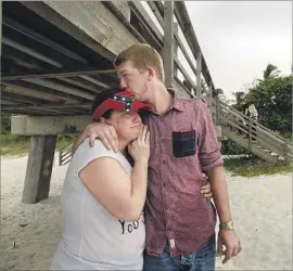  ??  ?? KATIE ALVAREZ is comforted by her son Jordan at the pier in Naples, Fla. “It’s going to be gone,” says the Naples native, who fears Irma will destroy it for good.