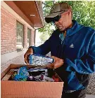  ?? ?? Davine Oliver looks over some of the groceries he received from a food pantry May 13 in Springfiel­d, Illinois.