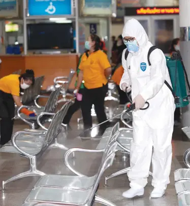  ?? PATTARAPON­G CHATPATTAR­ASILL ?? Workers disinfect the departure area at Mor Chit bus terminal in Bangkok. Passengers must pass through thermal scans to board interprovi­ncial buses and are denied travel if they have a fever.