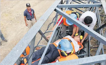  ?? RICHARD CASTRO / EXPRESO ?? Rescate. En medio del simulacro, el trabajador de una empresa simula quedar atrapado entre unos fierros donde trabaja. Los brigadista­s lo rescatan.