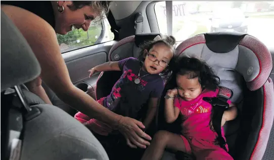  ?? LARS HAGBERG/THE CANADIAN PRESS ?? Johanne Wagner helps her four-year-old twins Phuoc, left, and Binh Wagner out of the school vehicle after their first day at junior kindergart­en at Ecole elementair­e publique Madeleine de Roybon in Kingston last Thursday. The girls, who both had a liver transplant earlier this year, are now thriving.