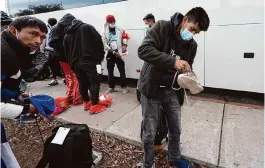  ?? Gregory Bull/Associated Press ?? Hundreds of migrants were dropped off Friday at a sidewalk bus stop in San Diego after local government funding for a reception center ran out of money.