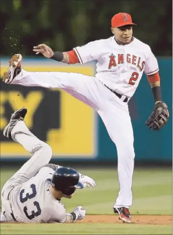  ?? Jeff Gross Getty Images ?? ERICK AYBAR STEPS OVER Nick Swisher after completing a double play in the second inning.