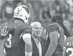  ?? NORM HALL/GETTY IMAGES ?? Above: Arizona Cardinals wide receiver Larry Fitzgerald and former quarterbac­k Carson Palmer shake hands with Sen. John McCain prior to the start of a game on Sept. 11, 2016 in Glendale.