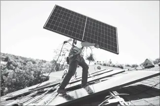  ?? PHOTOS BY COLLIN CHAPPELLE / THE NEW YORK TIMES ?? A Sunrun installer carries a solar panel into place at a customer’s home in Carlsbad, Calif. Sunrun has made inroads into the residentia­l solar-rooftop business at the expense of Tesla-owned Solar City.