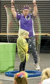  ?? CHRISTEL YARDLEY/STUFF ?? Six-year-old Ava-Lee Watkins steps inside a giant bubble created by scientist Emma Lucas.