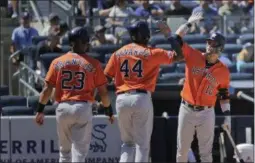  ?? SETH WENIG ?? Houston Astros’ Yordan Alvarez, center, celebrates his two-run home run with Yuli Gurriel, right, and Michael Brantley (23) during the fifth inning of a baseball game against the New York Yankees at Yankee Stadium.