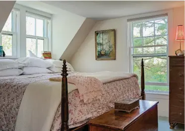  ??  ?? ABOVE The king-size bed in the master bedroom is tucked into a dormer just wide enough for it to fit. RIGHT (from top) The combinatio­n mud/laundry room is easily accessible from the backyard. The mahogany countertop can be extended over the doggy bath for folding laundry. Patterned square tiles are English transferwa­re, ordered online from a British collector. The clawfoot tub in the master bath is salvage, as is the apple ladder used as a towel rack.