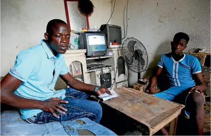  ?? PHOTO: REUTERS ?? Abdoulaye Dosso, left, an Ivorian migrant who voluntaril­y returned from Libya, sits with a relative at his home in Abidjan, Ivory Coast this week. Abuses against African migrants in Libya are likely to make migration the main talking point at this week’s summit of European Union and African Union leaders.