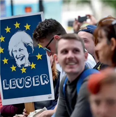  ?? AFP ?? A demonstrat­or holds a placard depicting an image of Theresa May, surrounded by the stars of the EU flag and with the words ‘Leuser’, as he stands outside the entrance to Downing Street on Friday, following the election results. —