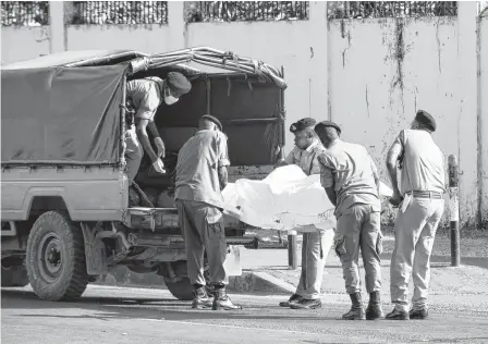  ?? EMMANUEL HERMAN • REUTERS ?? Tanzanian security forces remove the slain body of an attacker who was wielding an assault rifle, outside the French embassy in the Salenda area of Dar es Salaam, Tanzania, on Wednesday.