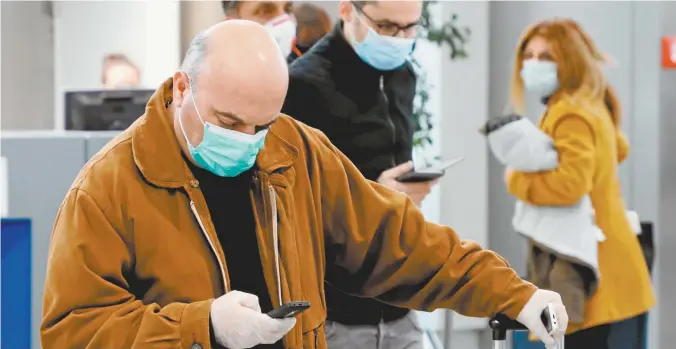  ??  ?? People wearing masks at Athens Internatio­nal Airport this week.