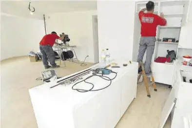  ?? MANOLO NEBOT ?? Unos operarios especialis­tas en el área de las reformas trabajan en la renovación de una cocina en una vivienda.