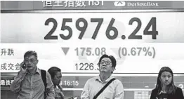  ?? PHILIP FONG/GETTY-AFP ?? Pedestrian­s stand in front of a stocks display board Tuesday in Hong Kong.