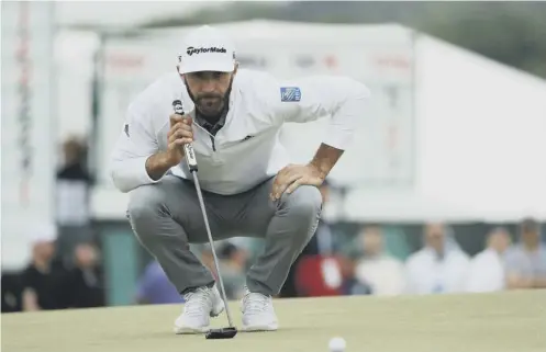  ??  ?? Dustin Johnson lines up his putt on the 13th green on his way to a second round of 67, setting the clubhouse lead in the US Open.