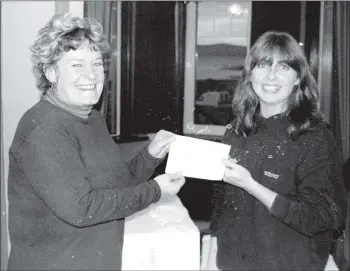  ?? 01_B48twe05 ?? Fiona Brown presents a cheque for £470.30 to Arran Ladies Hockey Club captain Susan Currie from money raised by a hole-in-one competitio­n held during the Arran Challenge. The money will go towards a new kit for the junior team.