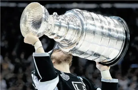  ?? HARRY HOW/GETTY IMAGES ?? Dustin Brown of the Los Angeles Kings lifts the Stanley Cup after the Kings’ 3-2 victory over the New York Rangers on Friday.