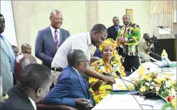  ?? - (Picture by Joseph Nyadzayo) ?? President Mugabe and First Lady Amai Grace Mugabe look as POSB bank teller Definate Mabvuazve demonstrat­es how ZANU-PF cards which are linked to POSB work as bank cards, while Vice President Emmerson Mnangagwa looks on during a Central Committee...