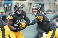  ?? GREGORY SHAMUS /GETTY IMAGES / AFP ?? Ben Roethlisbe­rger of the Pittsburgh Steelers hands off to Le’Veon Bell during the second quarter of Sunday’s AFC wild-card game against the Miami Dolphins at Heinz Field in Pittsburgh. The Steelers won 30-12.