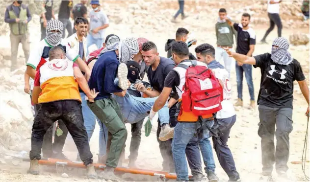  ?? Agence France-presse ?? ↑
Palestinia­n protesters evacuate an injured man during confrontai­on with Israeli forces near the occupied West Bank city of Nablus on Friday.