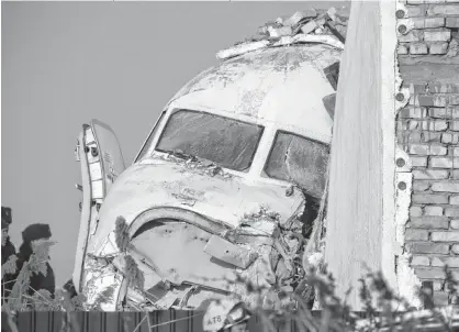  ?? MIKHEYEV REUTERS/PAVEL ?? Emergency and security personnel are seen at the site of the plane crash near Almaty, Kazakhstan, on Friday.