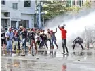  ??  ?? Police use water cannon to disperse protest