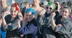  ?? PHOTOS BY GERRY KAHRMANN/PNG ?? Above: Four women dressed as Rosie the Riviter prepare for the 95th annual Vancouver Polar Bear Swim at English Bay on Thursday. Below: A participan­t emerges from the chilly waters.