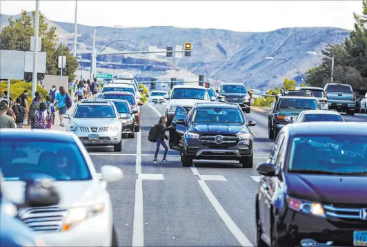  ?? Rachel Aston Las Vegas Review-journal @rookie__rae ?? A student leaving Greenspun Junior High School in Henderson gets in a car in the travel lane of Valle Verde Drive on Sept. 14.