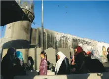  ?? (Muhammad Torokman/Reuters) ?? PALESTINIA­NS WAIT to cross the Kalandiya checkpoint between Ramallah and Jerusalem as they make their way to attend Ramadan prayers at al-Aksa mosque last month.