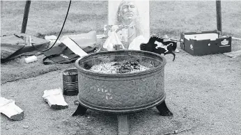  ??  ?? The sacred fire is exposed to the fall air after the canvas comes off the original and final teepee at the Justice for Our Stolen Children camp.