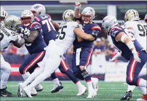  ?? Mary Schwalm / Associated Press ?? New England Patriots quarterbac­k Mac Jones takes a hit from New Orleans Saints linebacker Kaden Elliss (55) during the first half on Sunday in Foxborough, Mass.
