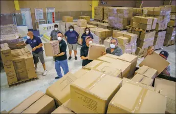  ?? NATHAN BURTON/Taos News ?? Members of Town of Taos Facilities and Events department, Taos Community Foundation, UNM Facilities, and the New Mexico Regional One Health Care Coalition load boxes of COVID and PPE supplies into a truck at the Taos Youth and Family Center on Tuesday (Sept. 14).