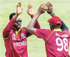  ??  ?? CWI PhotoWindi­es bowler Nikita Miller (left) celebrates the fall of a wicket with captain Jason Holder during a warm-up cricket match played between the Windies and United Arab Emirates at Harare Sports Club