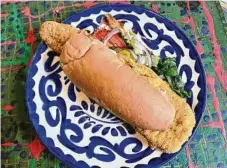  ??  ?? A nice, long filleted catfish po’ boy is on the menu at the Fifth Ward restaurant.