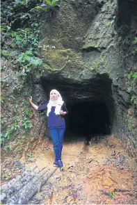  ??  ?? A tourist poses at the entrance of a tunnel, which sits right on the border of Thailand and Malaysia. Sukhirin district was establishe­d for the government to secure the border. The narrow tunnel leads to Malaysia’s Kelantan state.