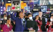  ?? PHOTO BY BEN HIDER/INVISION/AP ?? Eric Adams holds up a framed photo of his mother, at his swearing-in as New York mayor during the Times Square New Year’s Eve celebratio­n early Sunday in New York.