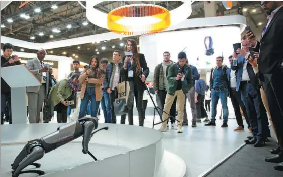  ?? MENG DINGBO / XINHUA ?? Visitors check out Xiaomi’s quadruped robot CyberDog during the Mobile World Congress 2023 in Barcelona, Spain, last March.