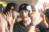  ?? Ross D. Franklin / Associated Press ?? Giants outfielder Hunter Pence gets a dugout greeting after scoring on Michael Morse’s double in the sixth inning.