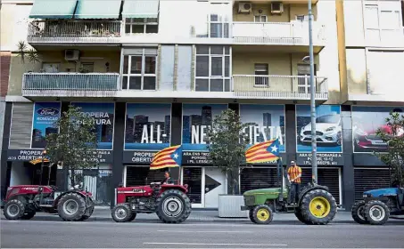  ??  ?? Going all out: Supporters of Catalan independen­ce driving tractors decorated with separatist flags into the city centre during a demonstrat­ion in Barcelona, Spain. — Bloomberg