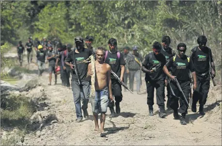  ?? ERALDO PERES — THE ASSOCIATED PRESS ?? Altemir Freitas Mota carries a tool used in cutting down trees as he leads Tenetehara Indigenous men to his group’s campsite near Paragomina­s, Brazil, on Sept. 8.